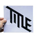 Black TITLE MTB die cut logo sticker held in hand on white background