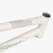 Close-up of WETHEPEOPLE TRIGGER FRAME BMX bike frame in white with Linda Grabner signature graphics