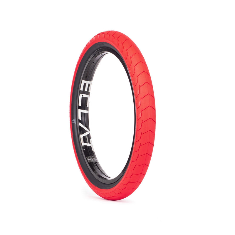 Red ÉCLAT Decoder BMX tire with micro knurling tread pattern and black rim showing ÉCLAT branding