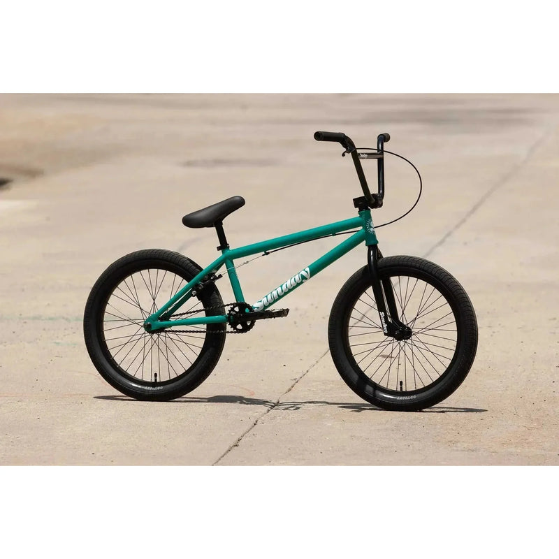 Green Sunday Primer 20-inch BMX bike with black tires and handlebars on concrete surface