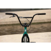 Front view of a Sunday Primer 20" BMX bike with black handlebars and green frame in an outdoor setting.