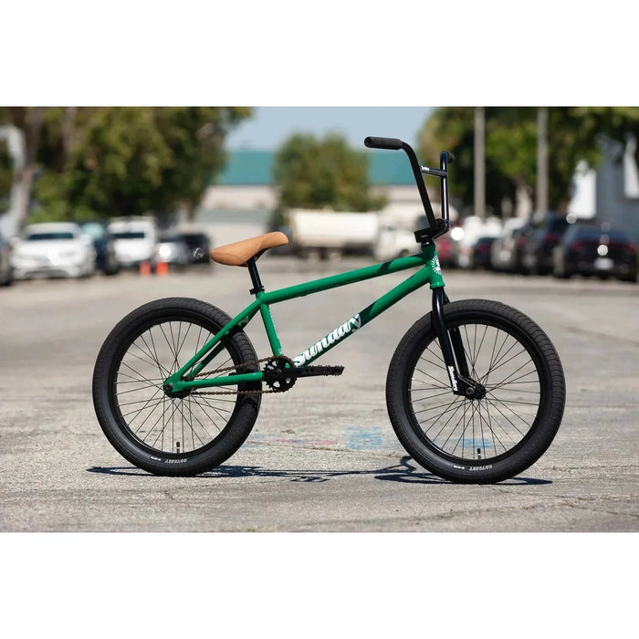 Green Sunday Forecaster 20-inch BMX bike with tan seat and black wheels on city street background
