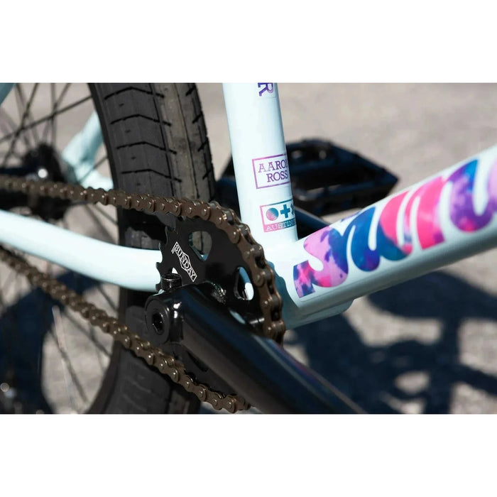 Close-up of the chain and chromoly frame on the matte sky blue Sunday Forecaster Ross BMX bike with branded decals.