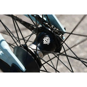 Close-up of black sealed front hub with Odyssey Clutch v2 Freecoaster on Sunday Forecaster Ross 20" complete bike in matte sky blue frame