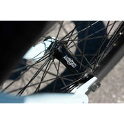 Close-up of black Sunday Forecaster Ross bike hub with spokes and light blue frame detail
