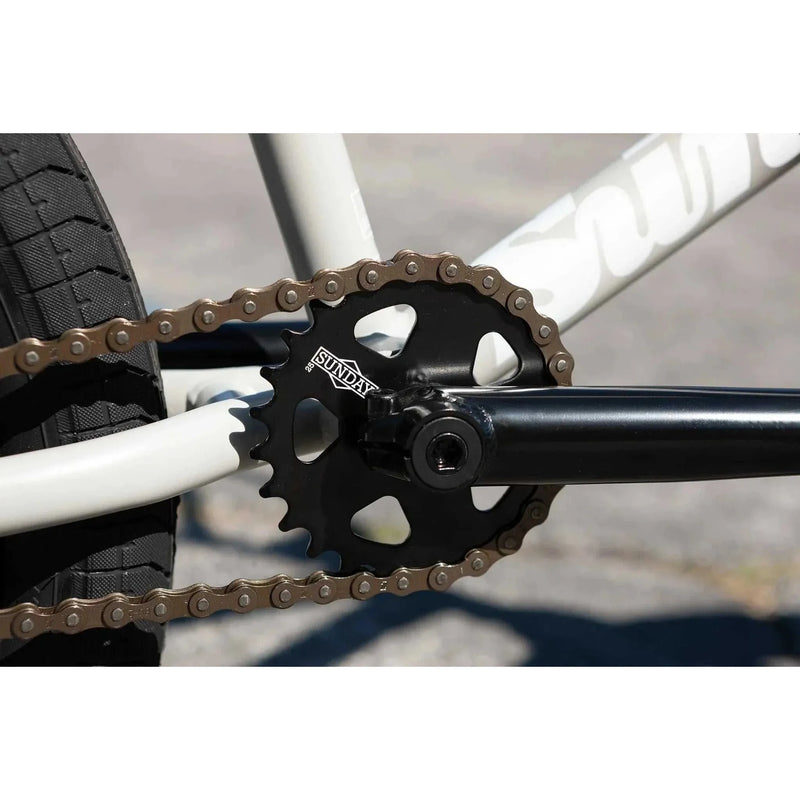 Close-up of Sunday Forecaster bike black sprocket and crank with chain on white frame