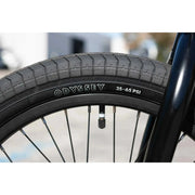 Close-up of Sunday Forecaster Odyssey 20-inch tire and black rim with valve stem and spokes
