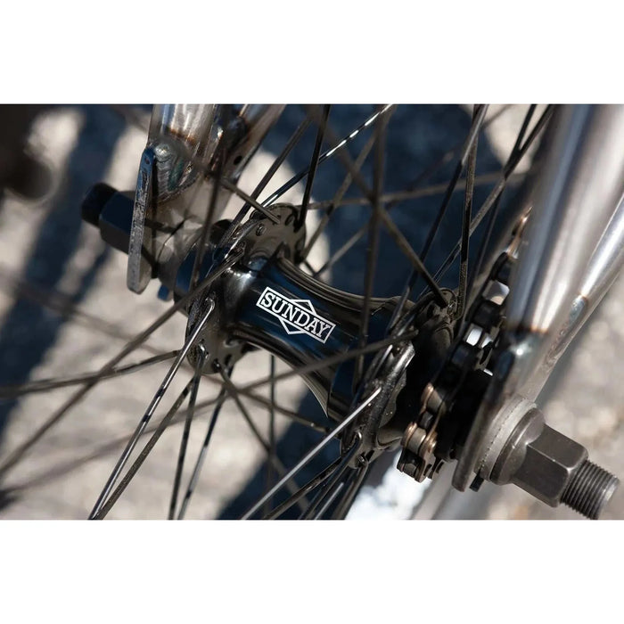 Close-up of the Sunday Forecaster bike's front sealed hub with spokes and part of the chromoly fork visible.