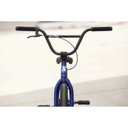 Front view of blue Sunday Model C 24" BMX complete bike with black handlebars and grips against a blurred background