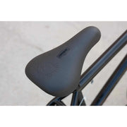 Close-up of black Sunday Model C BMX bike seat with logo on matte black frame.