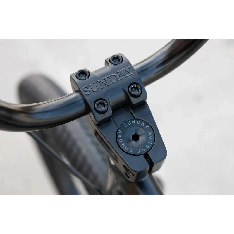 Close-up of black SUNDAY MODEL C bike handlebar stem clamp with embossed SUNDAY logo