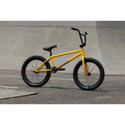 Matte mustard Sunday EX Arteaga 20-inch BMX bike with chromoly frame and black tires on skatepark pavement.
