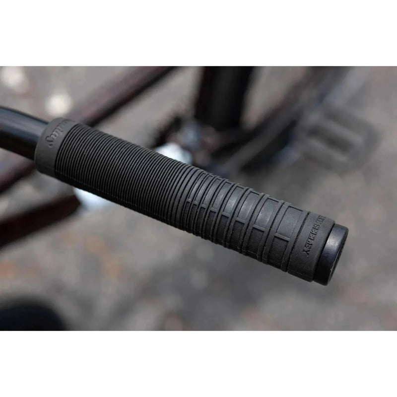 Close-up of black SUNDAY EX ELSTRAN BMX bike handlebar grip with textured pattern.