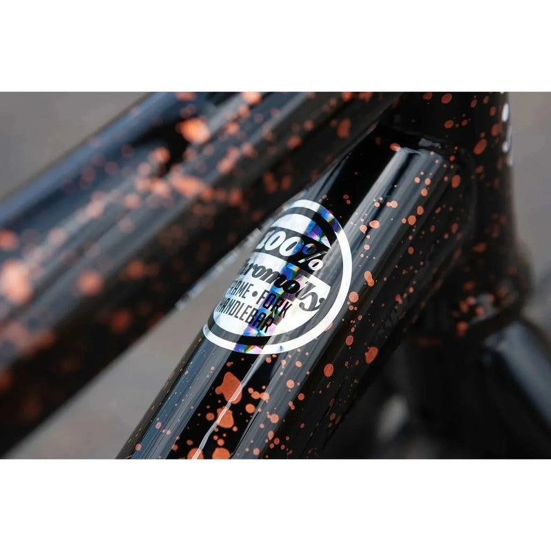Close-up of Sunday EX Elstran BMX bike frame with gloss black and copper splatter paint and 100% chromoly sticker