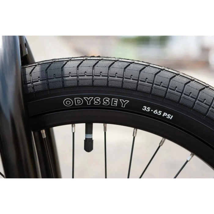 Close-up of Odyssey brand tire on Sunday EX Elstran 20" complete BMX bike wheel with black spokes and valve stem.