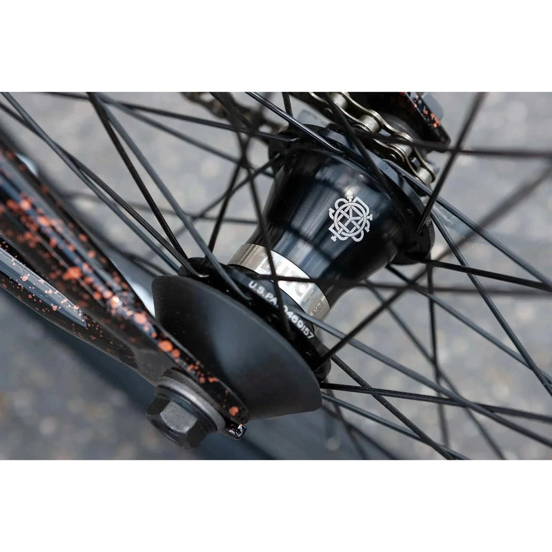 Close-up of SUNDAY EX ELSTRAN bike's black sealed front hub with spokes and copper speckled frame details