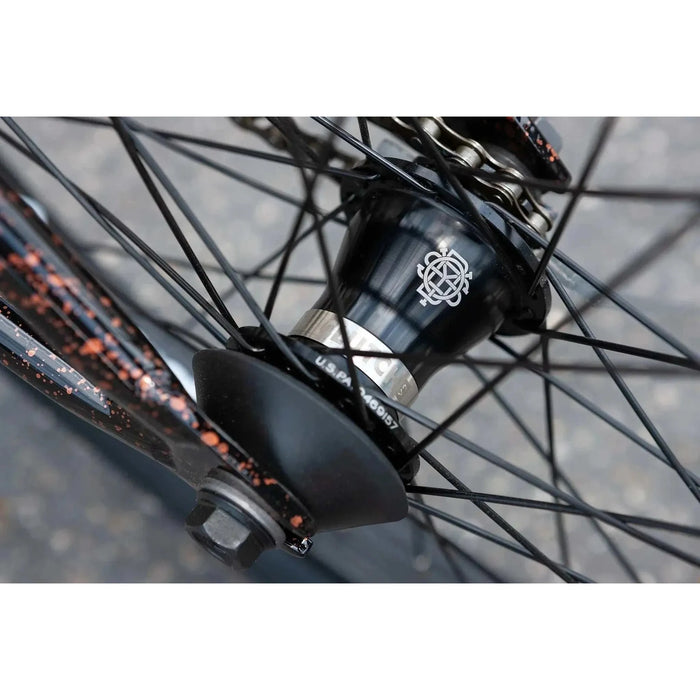 Close-up of SUNDAY EX ELSTRAN bike's black sealed front hub with spokes and copper speckled frame details