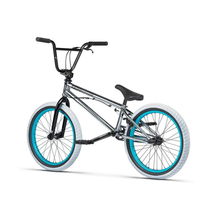 RADIO Astron FS complete BMX bike with chrome frame, black handlebars, and white tires with blue rims.
