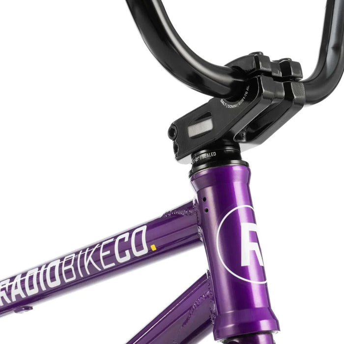 Close-up of purple RADIO DARKO bike frame and black handlebars with Radio Bike Co branding, designed for street riding.