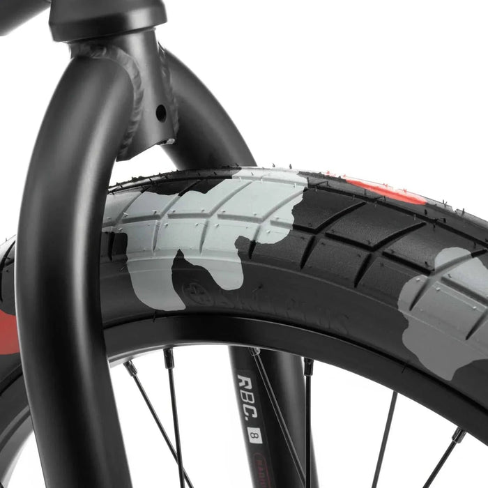Close-up of RADIO DARKO bike front tire and black fork with camo pattern tire design and strong welds on frame