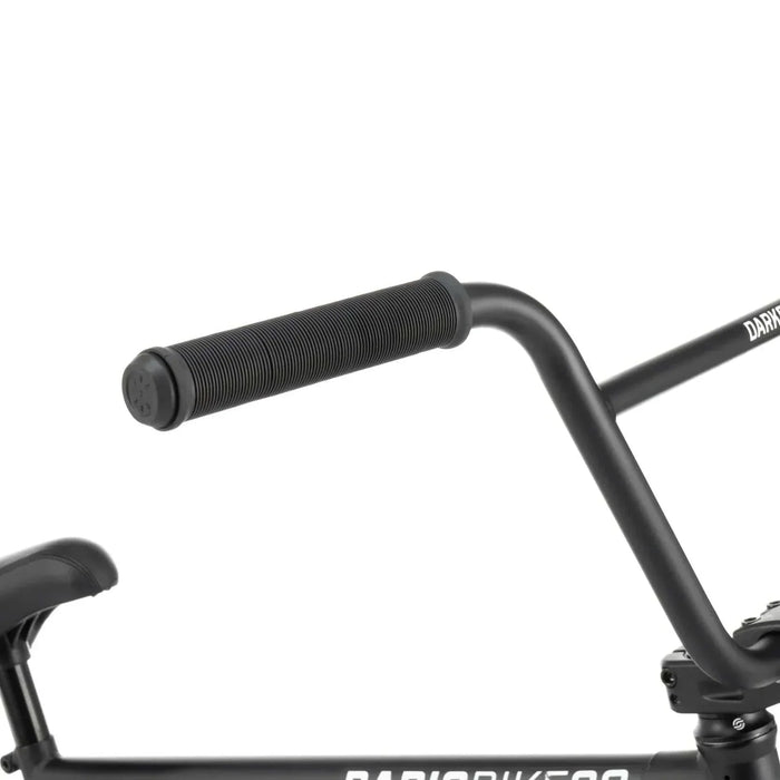 Close-up of RADIO DARKO bike handlebars and seat showing black flangeless grips and fat padded combo seat