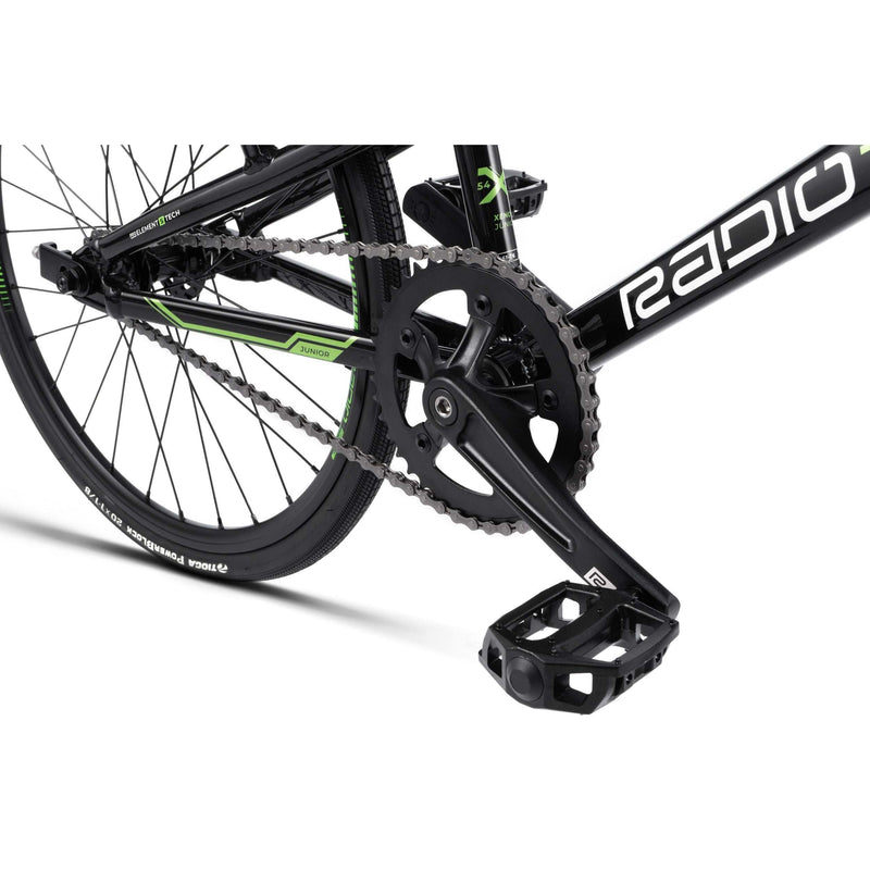Close-up of RADIO RACELINE XENON JUNIOR bike black crankset, chain, and pedal with 20-inch tire and alloy frame details
