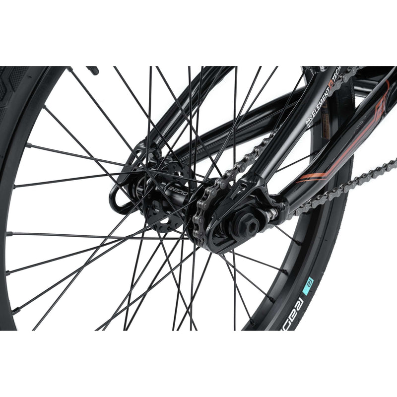 Close-up of Radio Raceline Xenon PRO complete bike's rear wheel, showing disc-ready dropouts, 43T alloy sprocket, KMC chain, and Argon PRO rim.