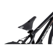 Close-up of Radio Raceline Xenon PRO black bike seat and part of frame with tire visible, highlighting sleek design and branding.