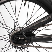 Close-up of RADIO RACELINE QUARTZ PRO bicycle's rear wheel, disc brake, and chain assembly.