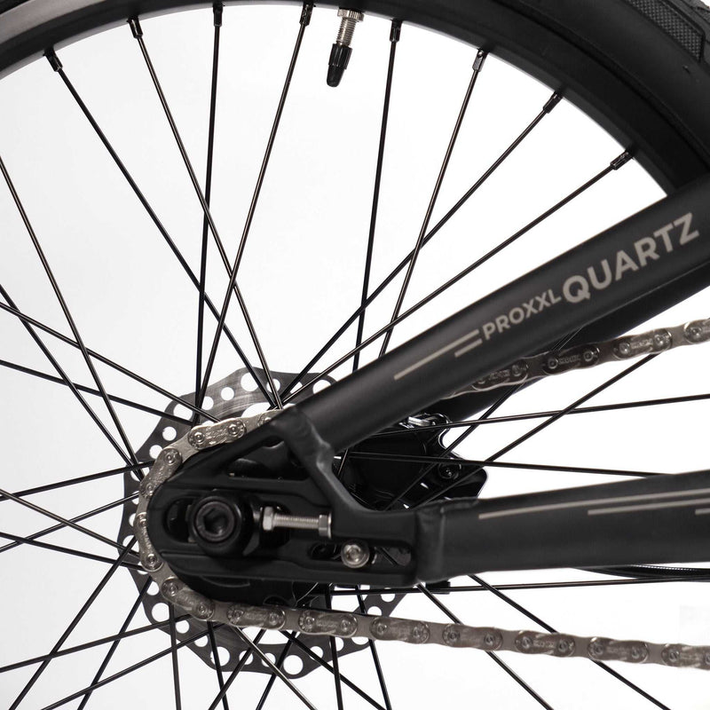 Close-up of RADIO RACELINE QUARTZ PRO bicycle's rear wheel, disc brake, and chain assembly.