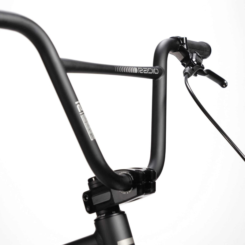 Close-up of RADIO RACELINE QUARTZ PRO bike black handlebar with brake lever and grip against white background