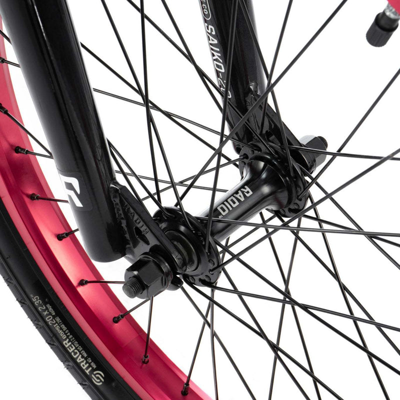 Close-up of RADIO SAIKO 20 bike front wheel hub and black fork with purple rim and spokes detail