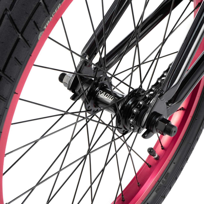 Close-up of RADIO SAIKO 20 bike rear wheel with black spokes and pink rim