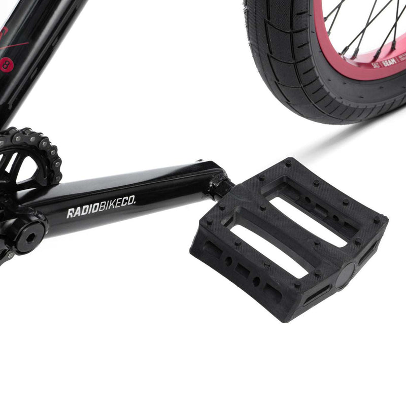 Close-up of RADIO SAIKO 20 bike black crank and pedal with partially visible rear tire and rim.