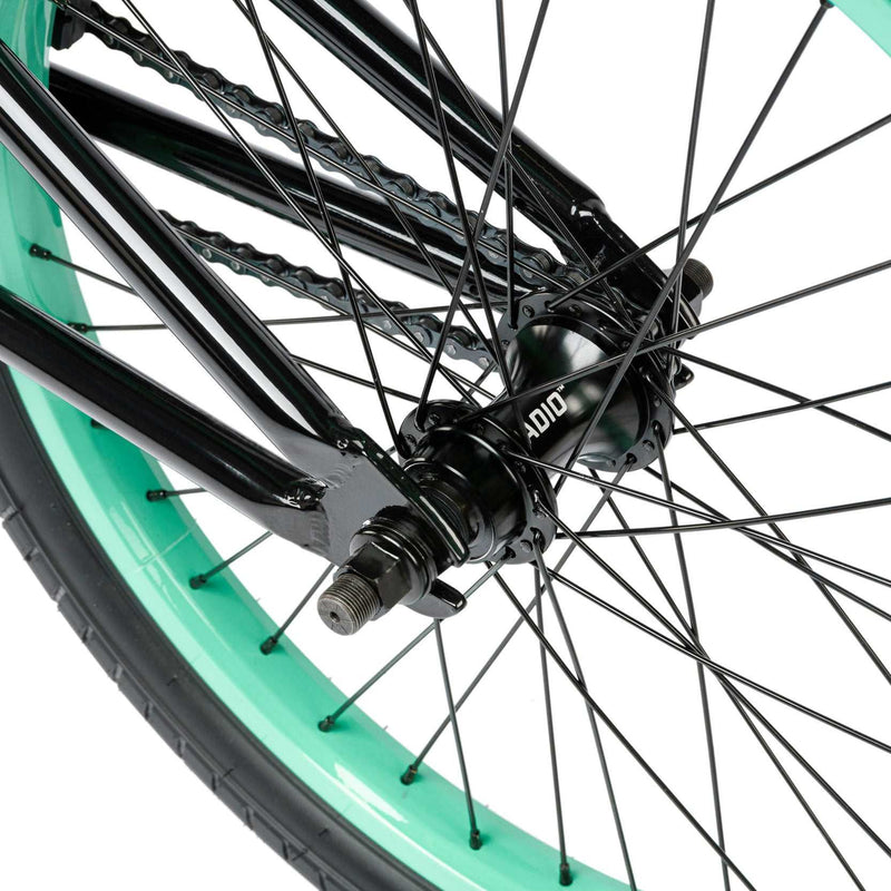 Close-up of RADIO SAIKO 20 bike rear wheel with black hub and turquoise rim
