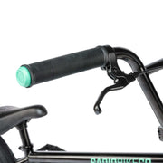 Close-up of RADIO SAIKO 20 bike's black handlebar grip and brake lever with part of the seat and frame visible