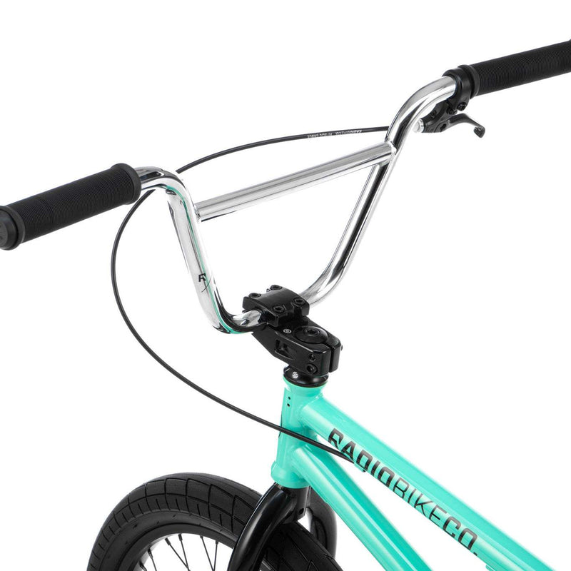 Close-up of RADIO SAIKO 20 BMX bike handlebars and front frame in turquoise with black tire