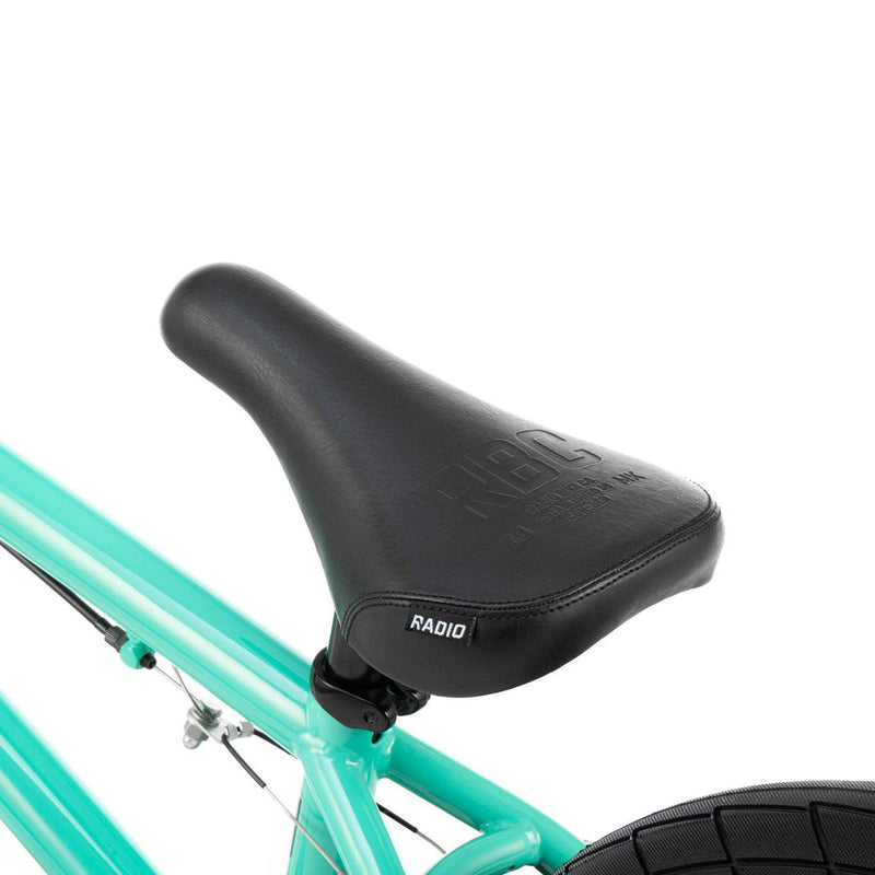 Close-up of black Radio Saiko 20 bike saddle on a teal frame showing detailed stitching and branding