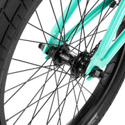 Close-up of the RADIO SAIKO 20 bike's black front wheel hub and spokes with teal frame accents.