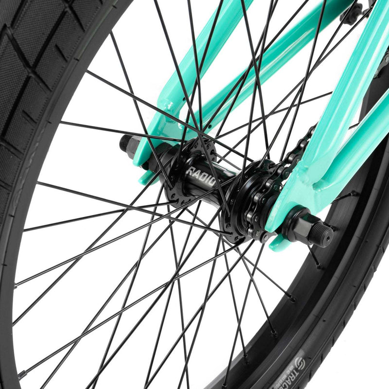 Close-up of the RADIO SAIKO 20 bike's black front wheel hub and spokes with teal frame accents.