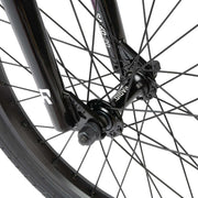 Close-up of the black Radio Saiko 20 bike front wheel and fork showing spokes and hub with RADIO SAIKO 20 branding