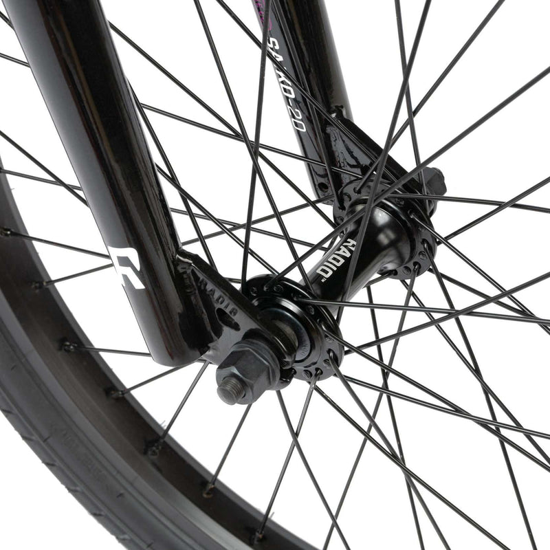 Close-up of the black Radio Saiko 20 bike front wheel and fork showing spokes and hub with RADIO SAIKO 20 branding