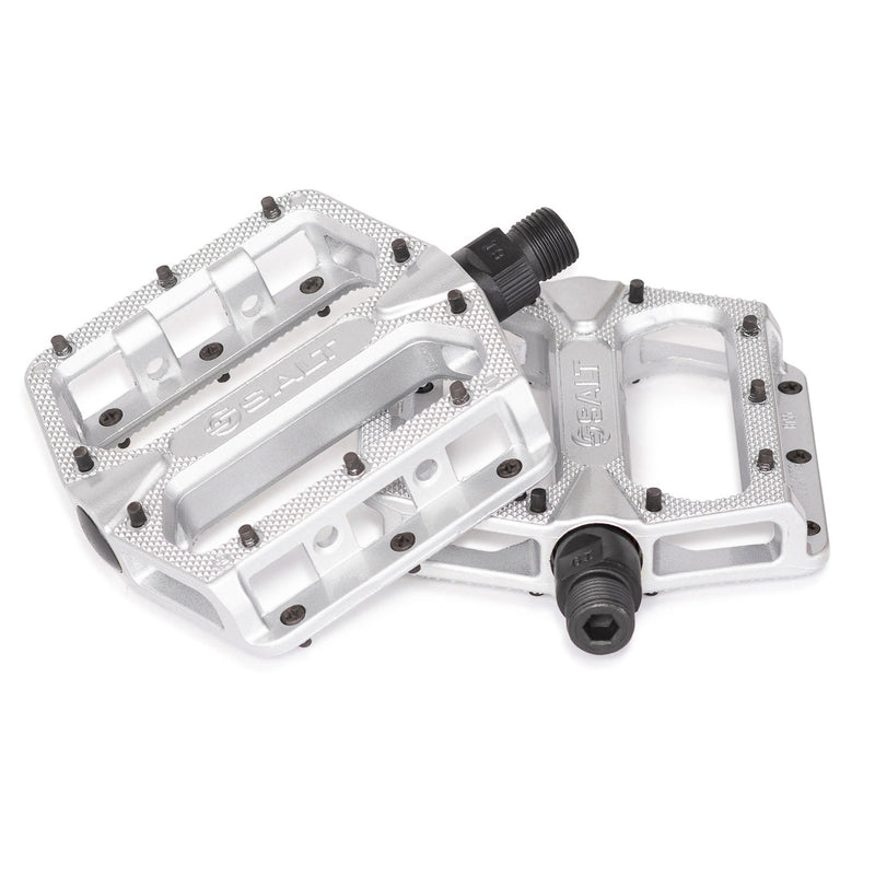 Slim alloy platform bicycle pedals with knurled body, replaceable steel pins, and crmo spindle, available in black, silver, and white.