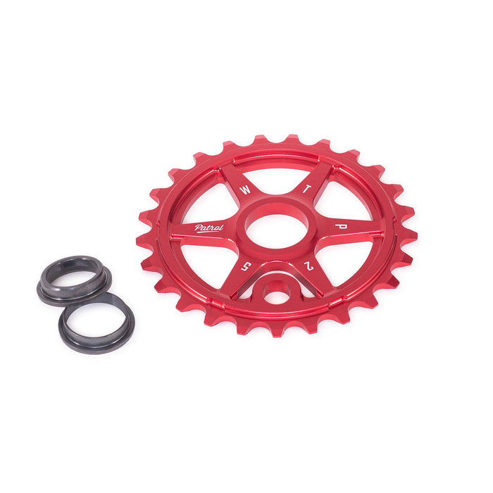 Red WETHEPEOPLE PATROL SPROCKET with offset teeth and 3 metal adapters for BMX bike chain line.