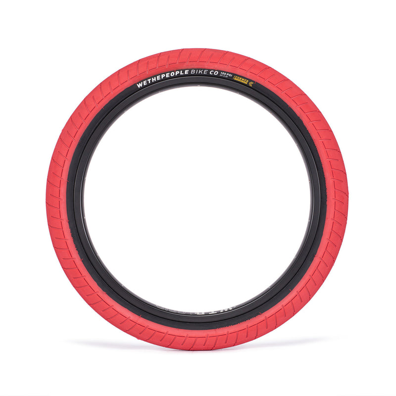 WETHEPEOPLE ACTIVATE TIRE with red sidewall, designed for durability and grip, featuring fast-rolling tread and cobweb technology.