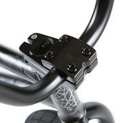 Close-up of black handlebar clamp and part of the frame of the Wethepeople Justice Bike with logo on the frame