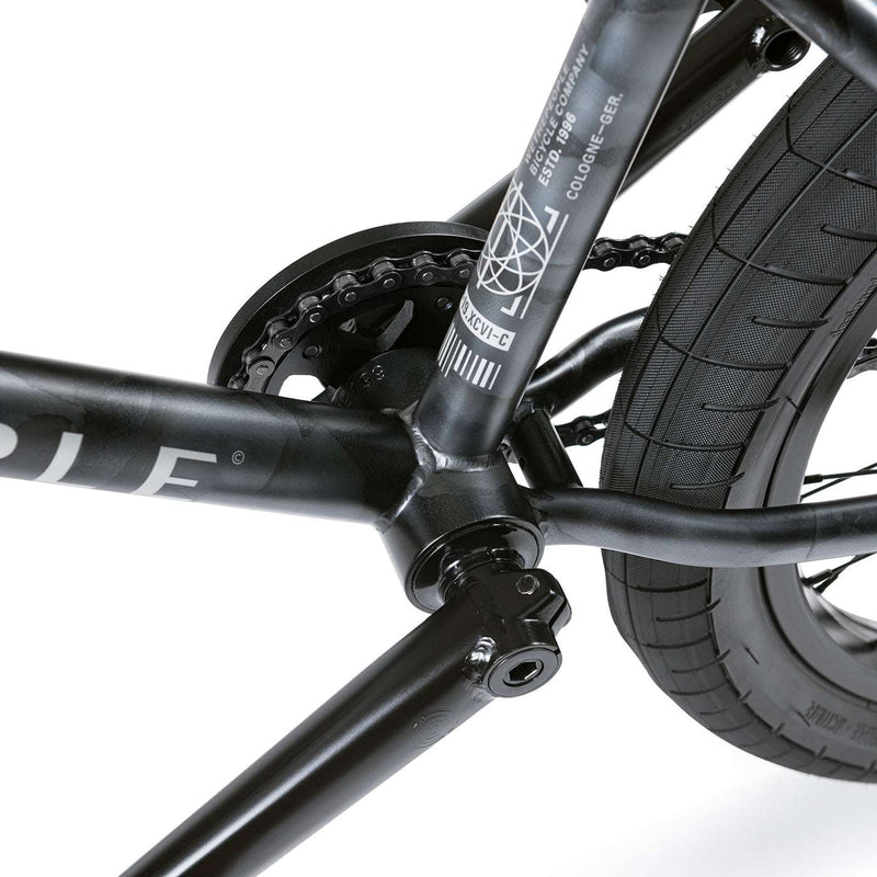 Close-up of the Wethepeople Justice Bike frame and crankset showing black 4130 chromoly construction and Activate tire tread detail