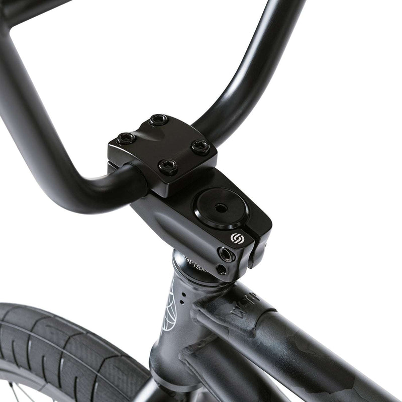 Close-up of black handlebars, stem, and front tire on the WETHEPEOPLE JUSTICE BIKE featuring a sturdy frame and urban BMX design