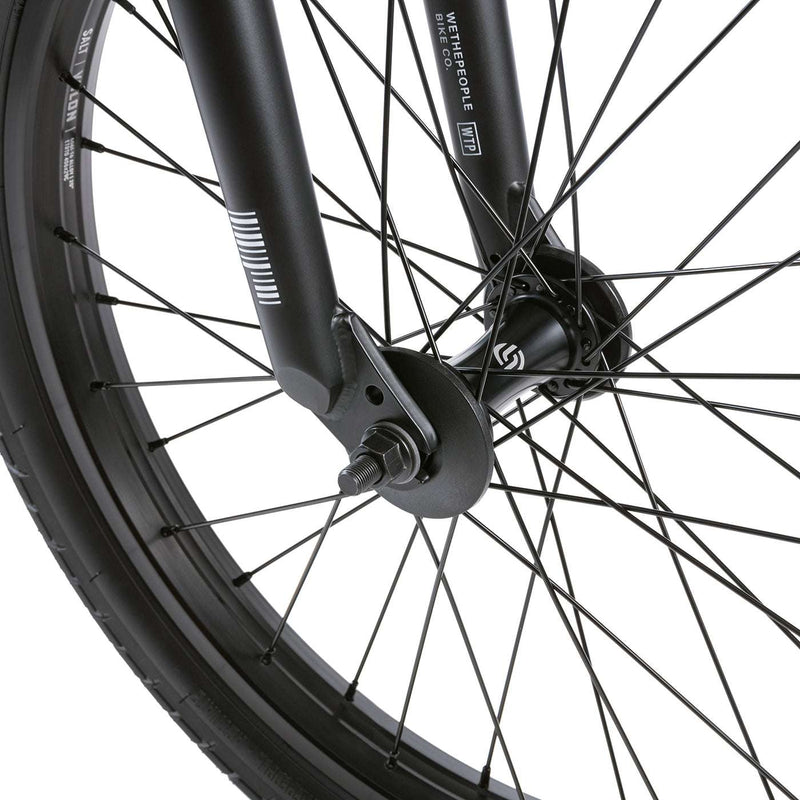 Close-up of front wheel and fork of WETHEPEOPLE JUSTICE BIKE showing black 22mm offset fork and salt pro hub with spokes