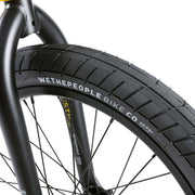 Close-up of Wethepeople Justice Bike front tire and fork with detailed branding on black urban BMX bike wheel and frame